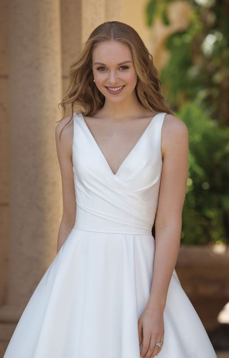 Woman wearing 44080 by Sincerity Bridal - Asymmetric Mikado Ball Gown with Draped Neckline and Pockets with a blurred outdoor background