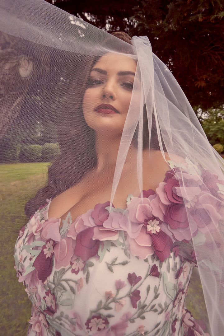 Woman wearing a floral dress with a veil in an outdoor setting