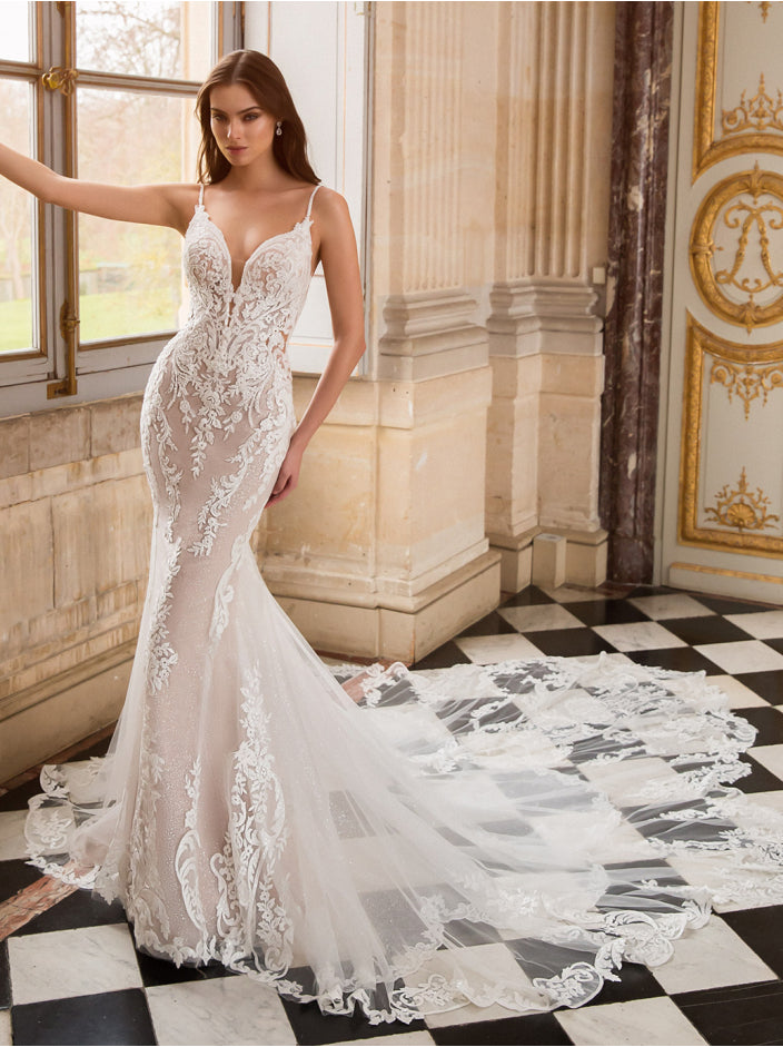 Model wearing a lace wedding dress in an elegant interior setting