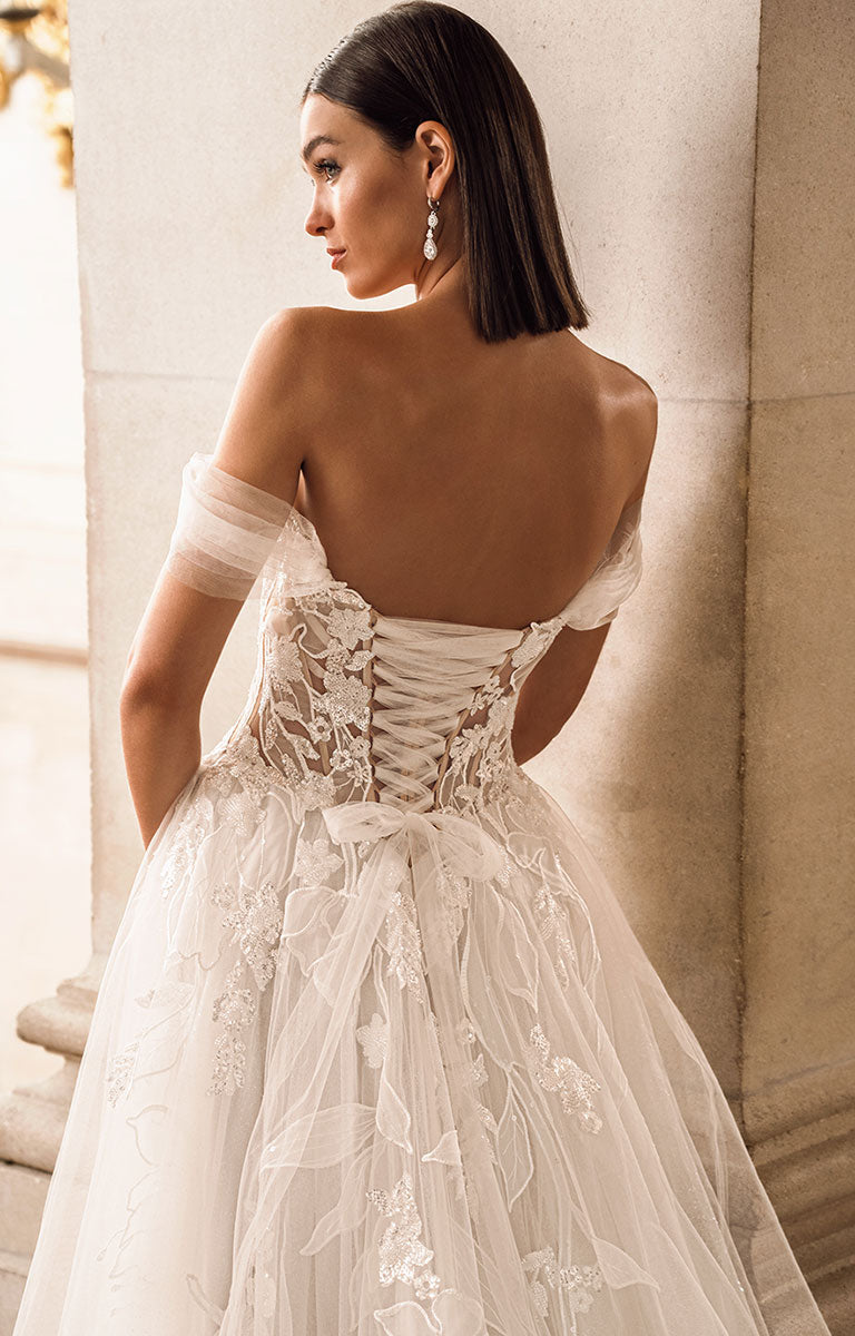 Woman wearing a white lace wedding dress with a soft focus background