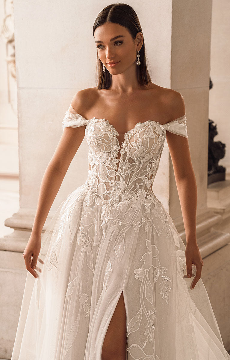 Woman wearing a white lace wedding dress in an elegant indoor setting
