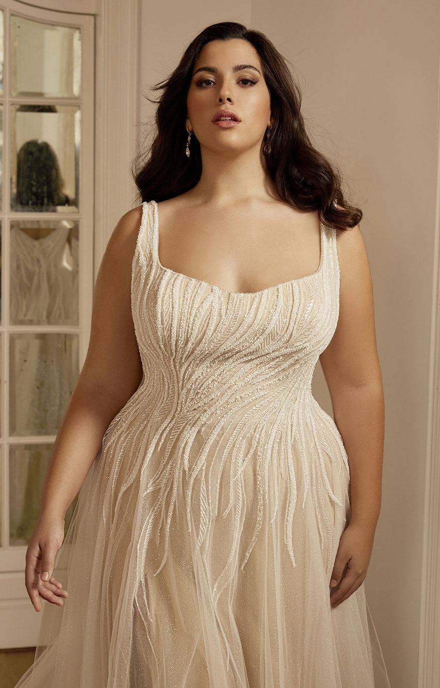 Woman wearing a white beaded gown in an indoor setting