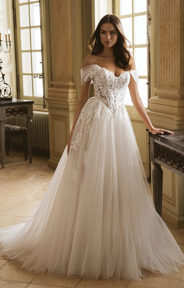 Woman wearing a white lace wedding dress in an elegant room.