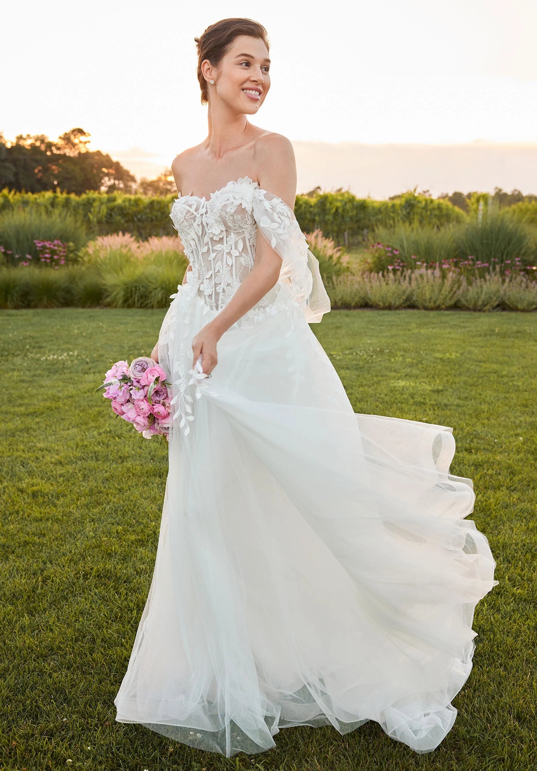 Woman in a white wedding dress holding a bouquet of flowers in a garden setting