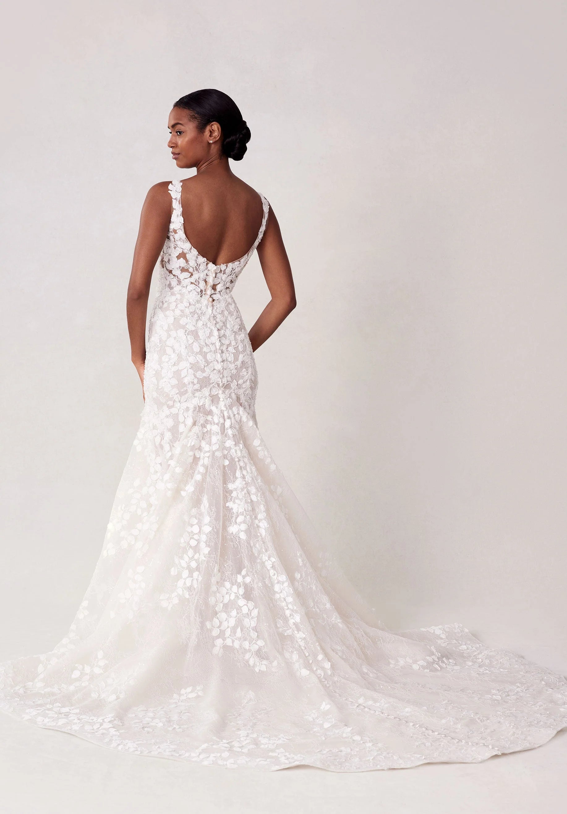 White lace wedding dress on a model against a white background