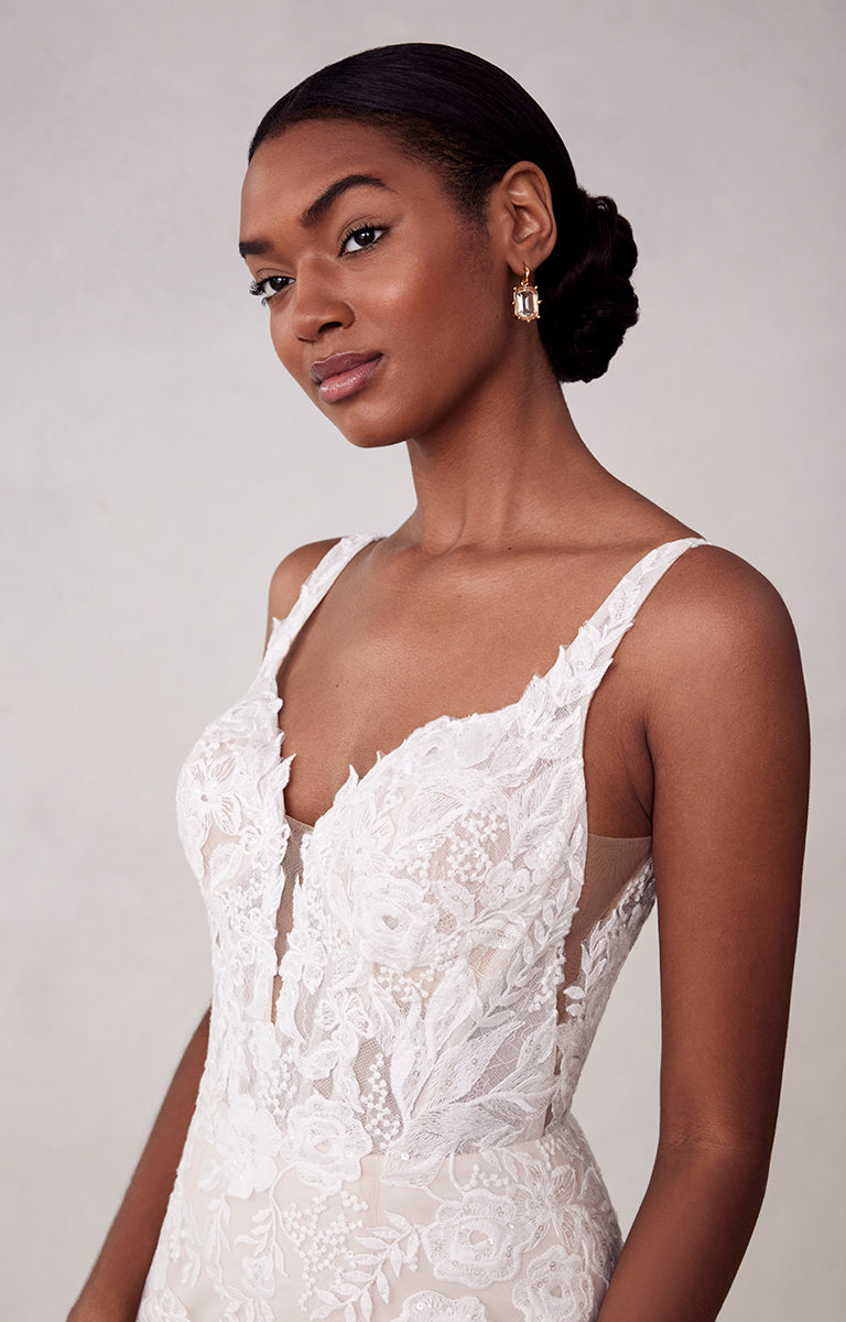 Woman wearing a white lace dress against a plain background