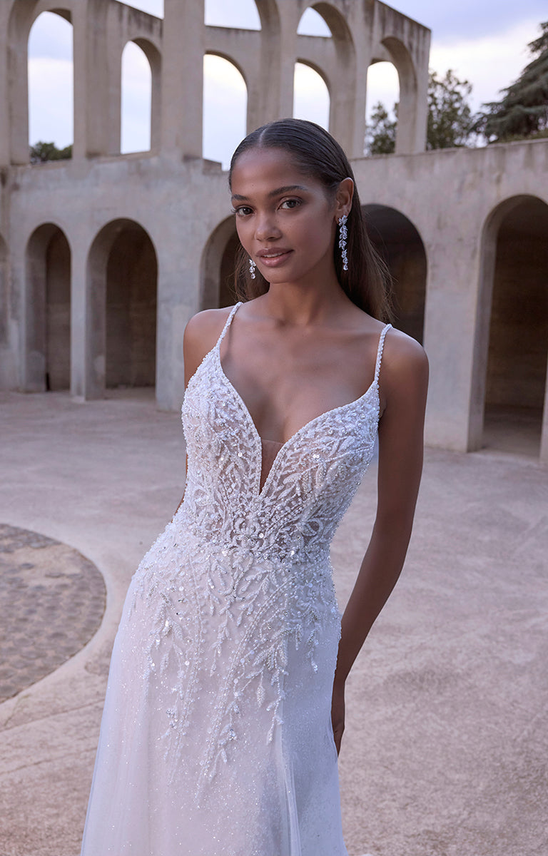 Woman in a white wedding dress standing in an architectural setting