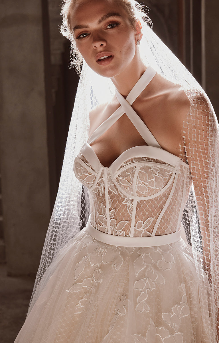 Woman wearing a white lace wedding dress with a veil.