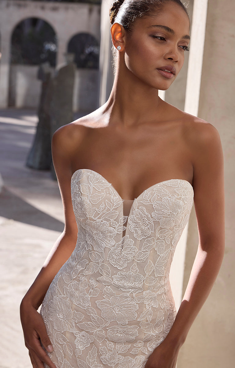 Woman wearing a strapless lace wedding dress in an outdoor setting