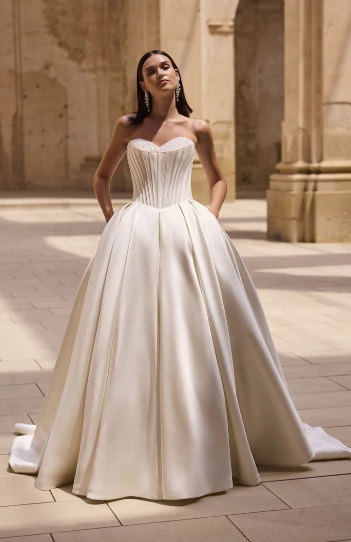 Woman in a white wedding dress standing in an ancient architectural setting