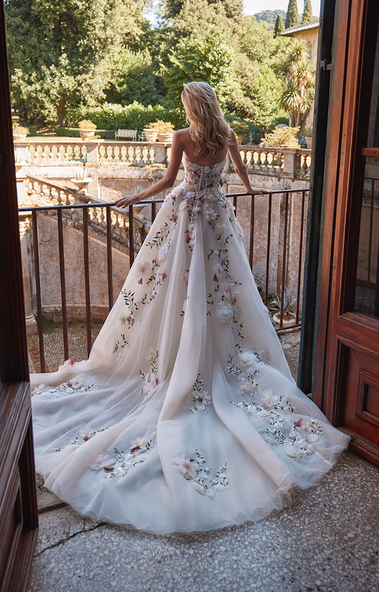 Woman in 63202BL Aadhya by Veni Infantino Bridal - Floral A-Line Wedding Dress with Sweetheart Neckline standing on a balcony with a scenic background