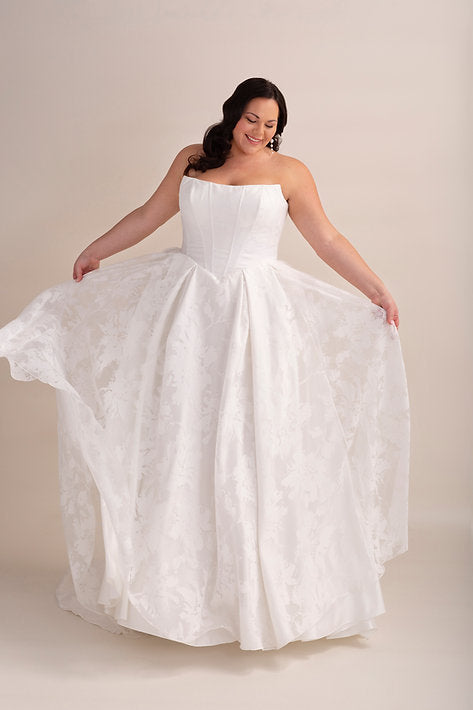 Woman wearing a white wedding dress on a plain background