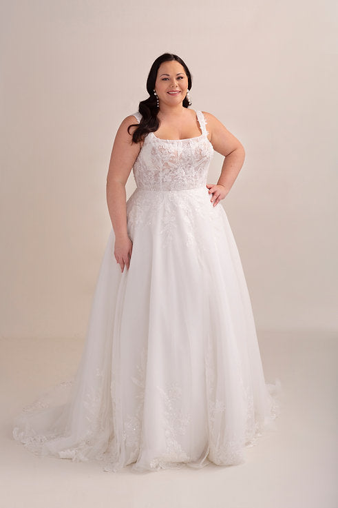 Woman wearing a white wedding dress with a beige background