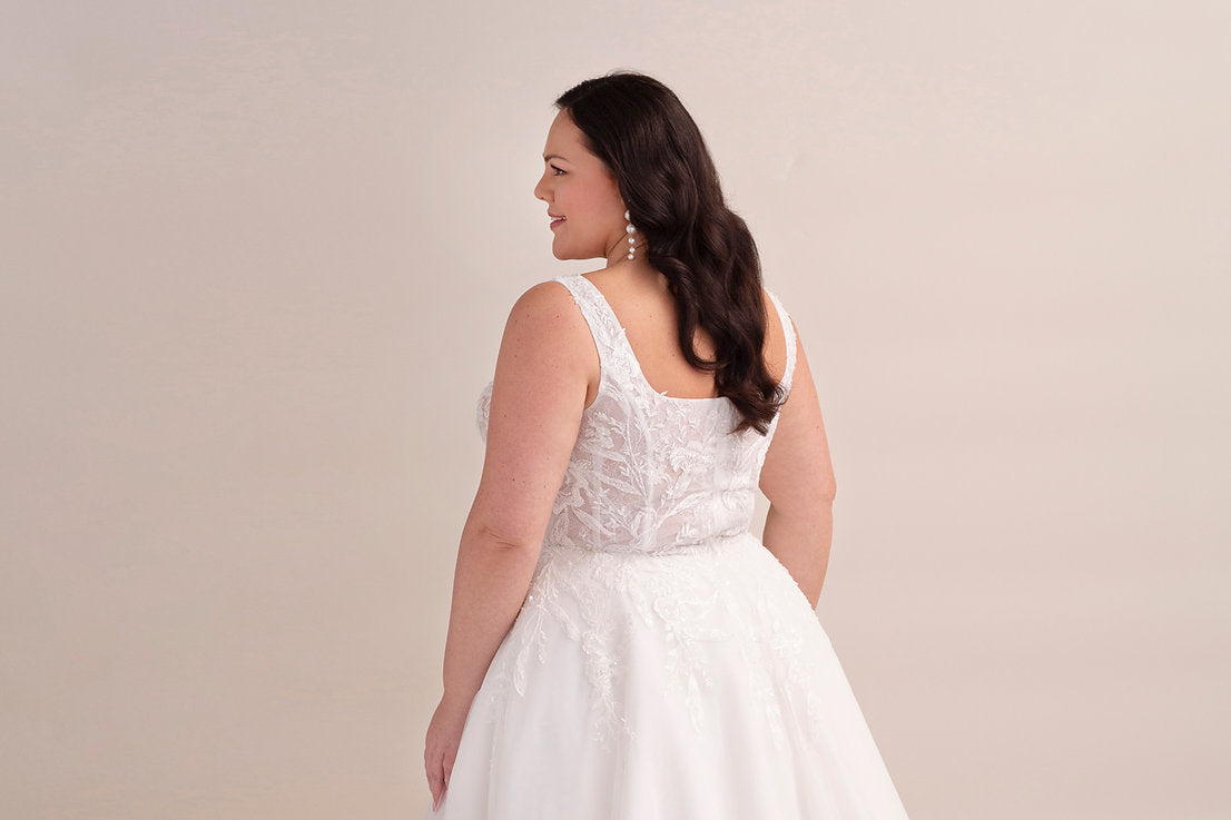 Woman wearing a white wedding dress against a beige background