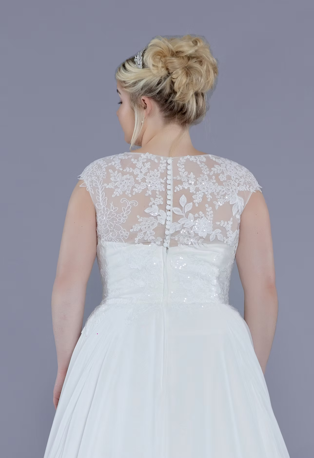 White lace wedding dress with a plain background
