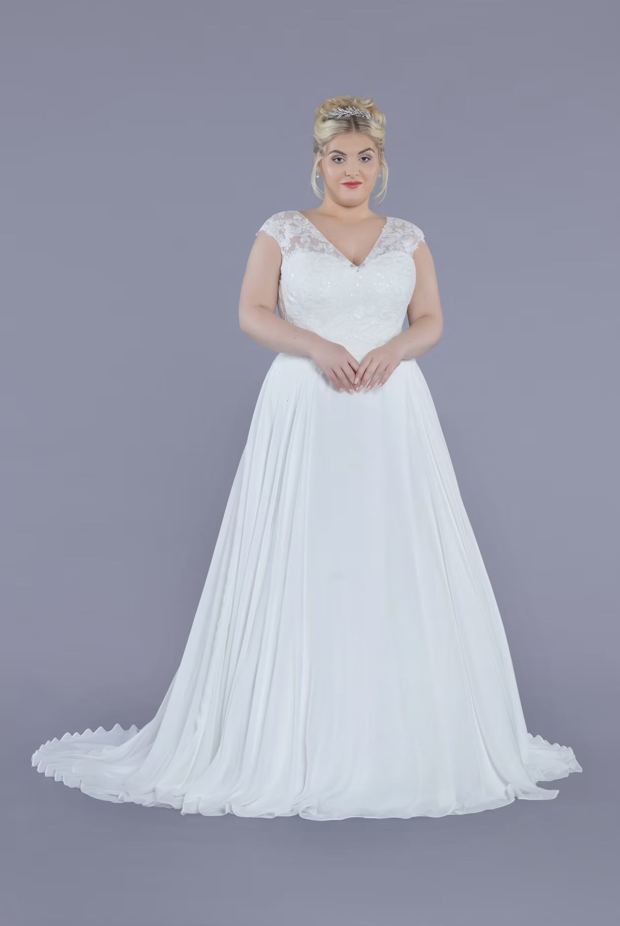 Woman wearing a white wedding dress against a gray background