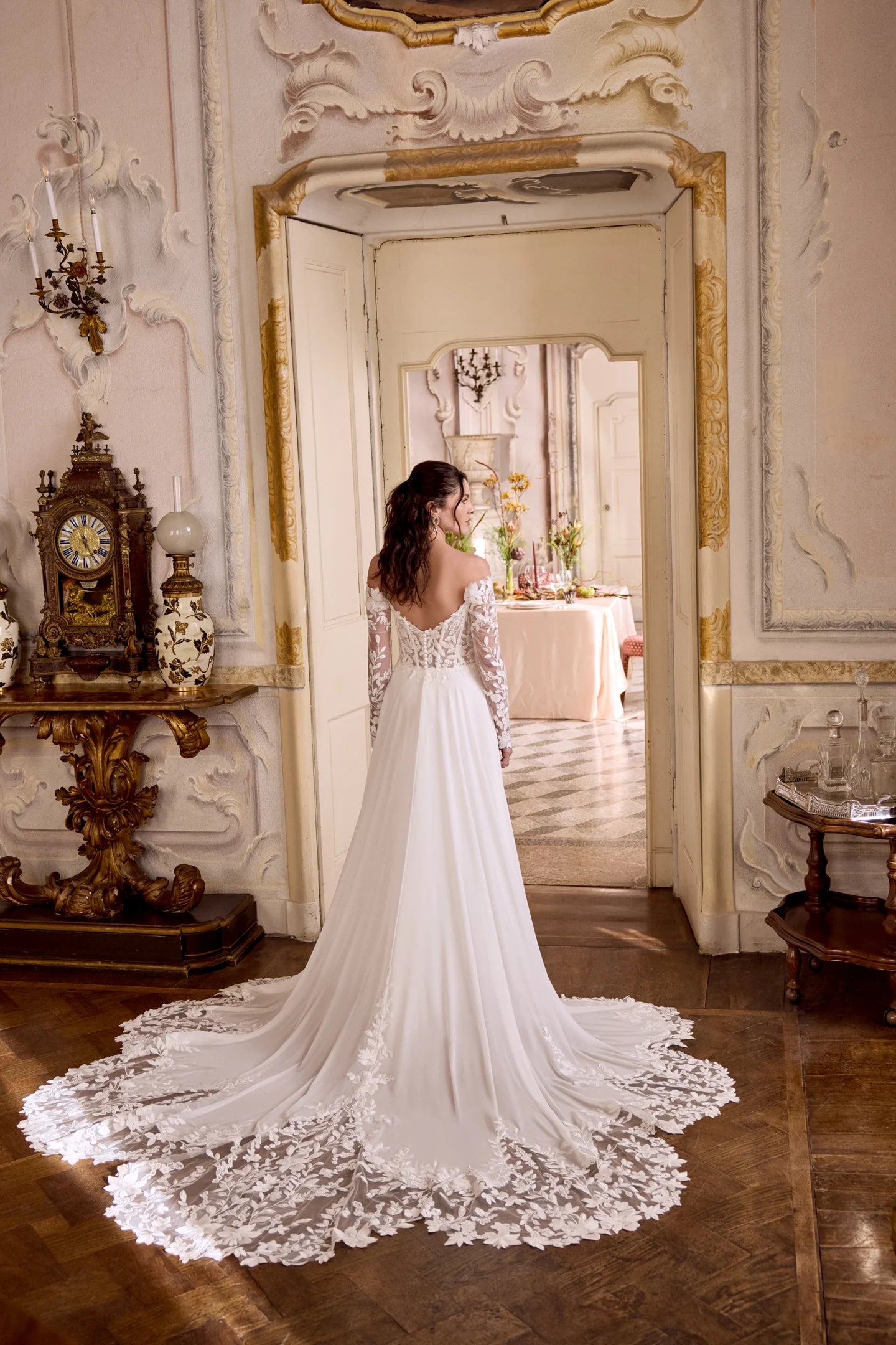 Woman in a white wedding dress standing in an ornate room with decorative elements.