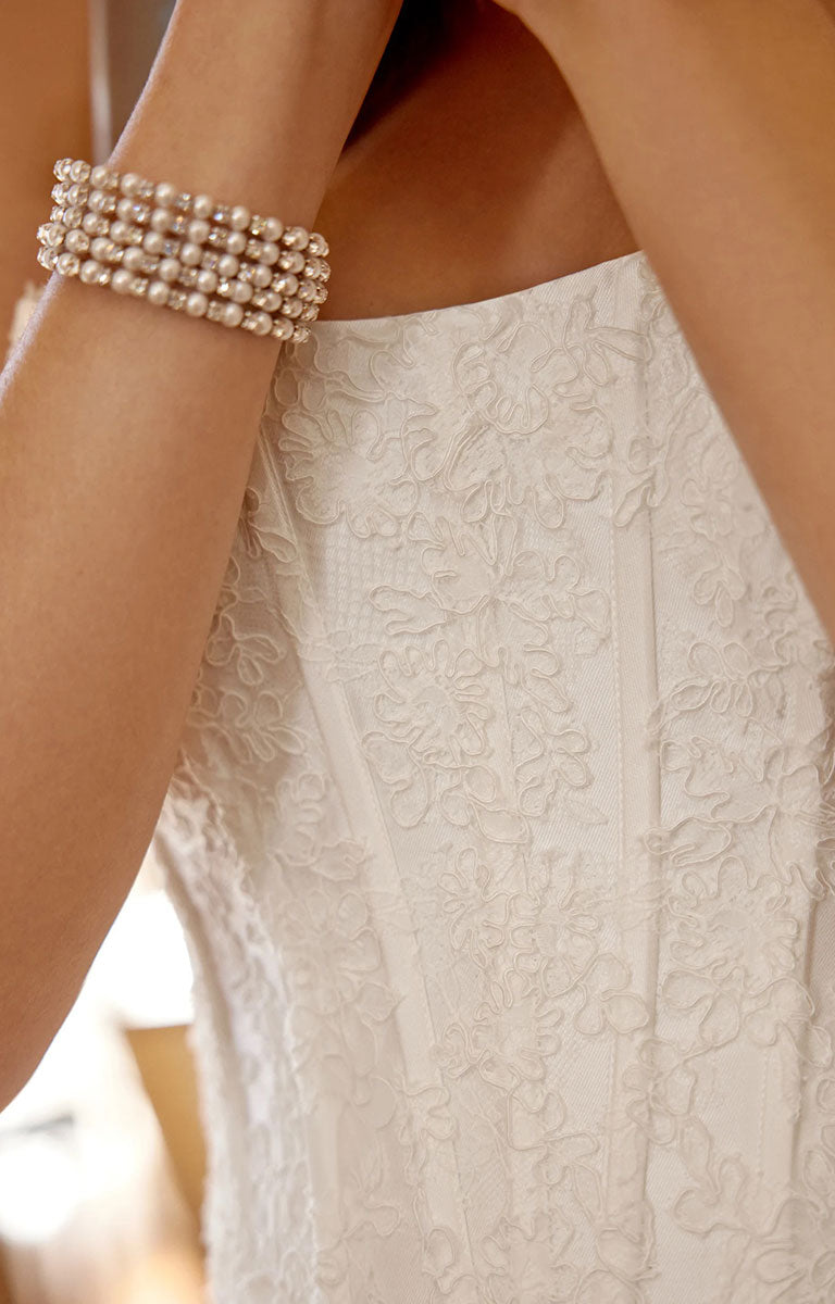 A close-up of a model wearing Marley 88519 by Justin Alexander - Stretch Mikado Fit-and-Flare Wedding Dress with Lace Appliqués and Optional Overskirt.