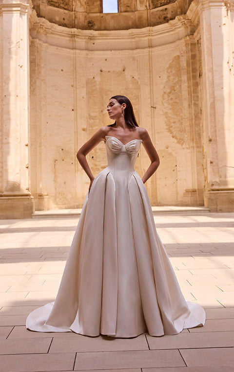Woman in a white dress standing in an ancient architectural setting