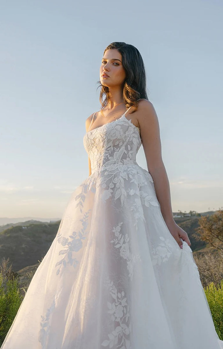 Woman in A1403 by Allure Bridals - Shimmering Lace A-Line Wedding Dress with Ballet Neckline standing outdoors with mountains in the background