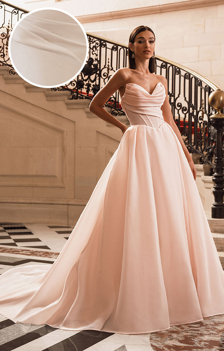 Woman in a Filippa Wedding Dress by Elysee - it is a strapless gown and she is standing in an elegant interior setting.
