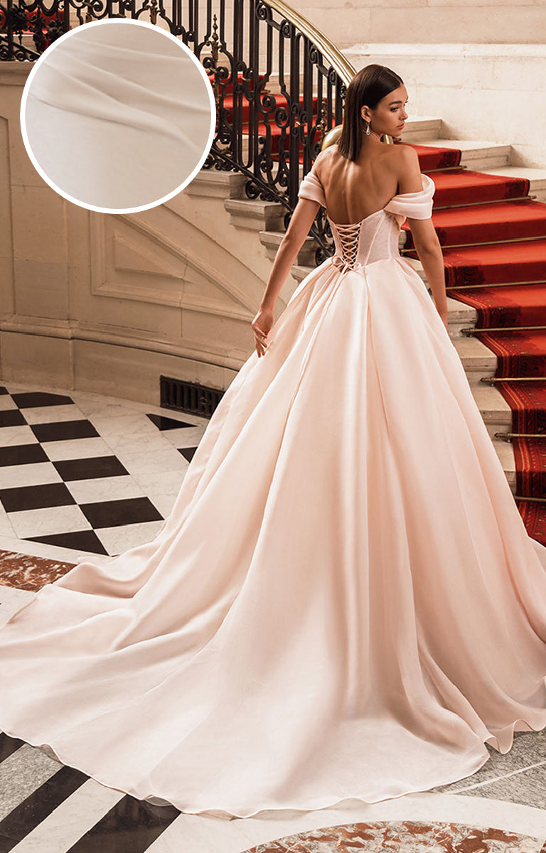 Woman in a Filippa Wedding Dress by Elysee - it is a strapless gown and she is standing in an elegant interior setting.