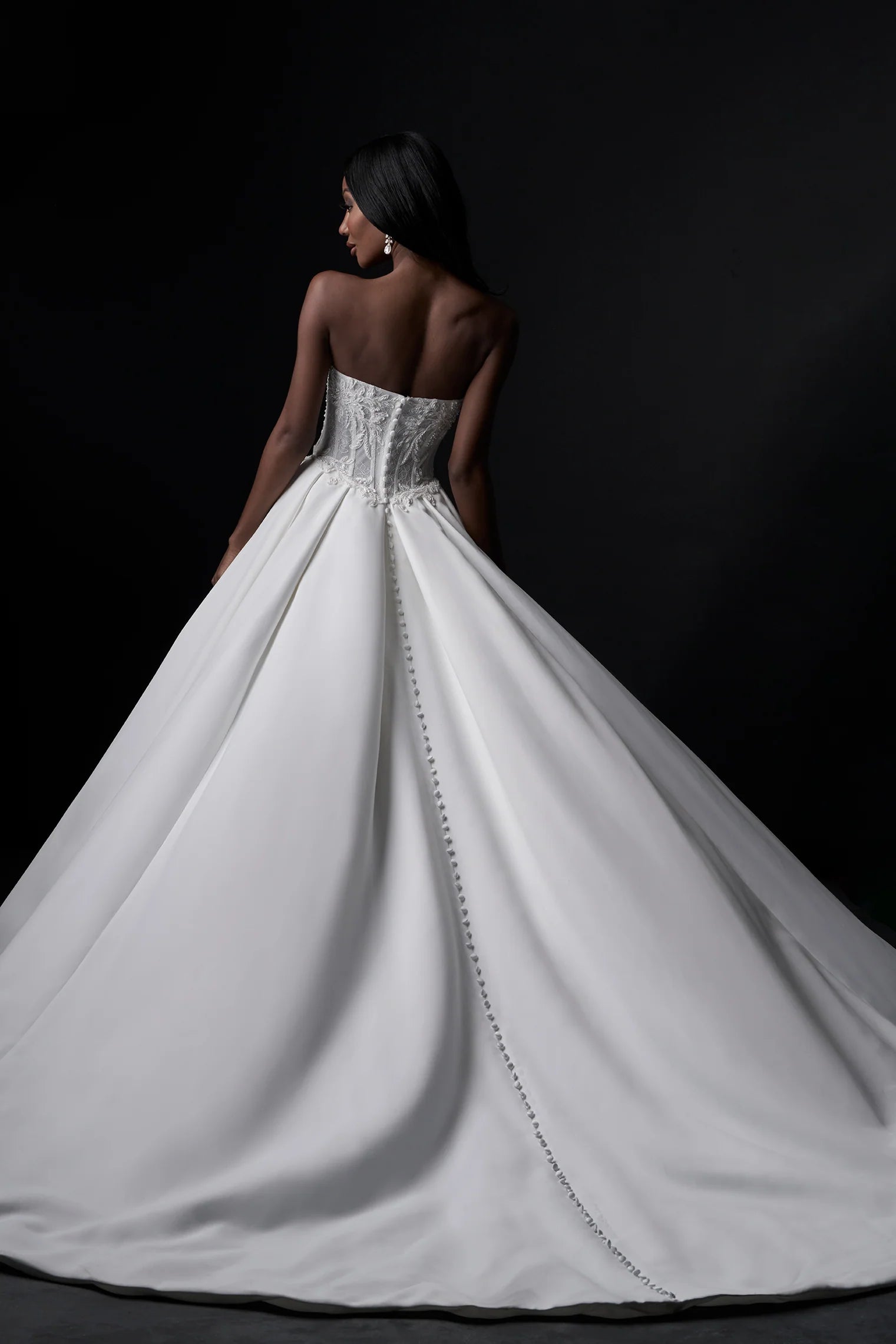 White wedding dress with intricate detailing on a black background