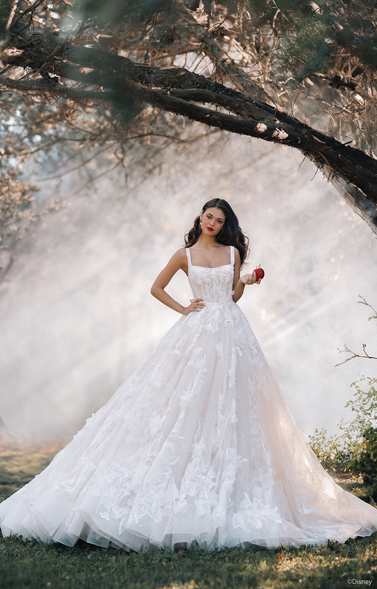 Woman in D447 Snow White - Disney Fairytale Weddings Wedding Dress standing under a tree with a soft, blurred background