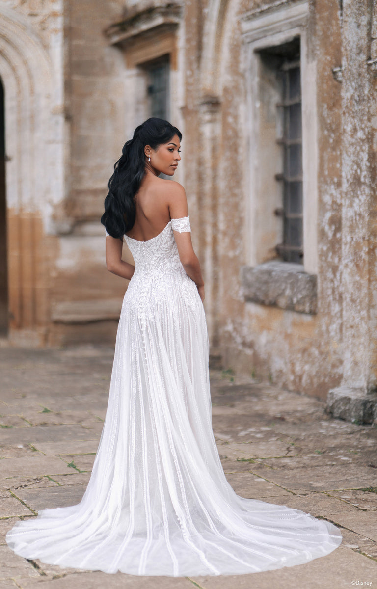 Woman wearing D474 Jasmine - Disney Fairytale Weddings Wedding Dress outside a grand country house. 