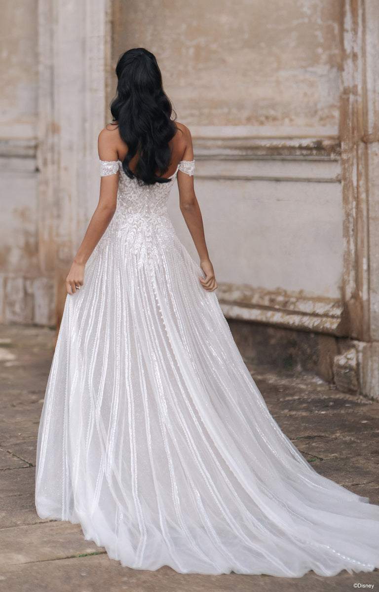 Woman wearing D474 Jasmine - Disney Fairytale Weddings Wedding Dress outside a grand country house. 