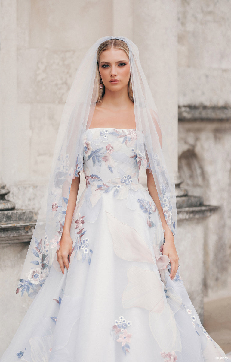 Woman wearing DP456 Rapunzel - Disney Fairytale Weddings Wedding Dress in front of a classic stone building.  