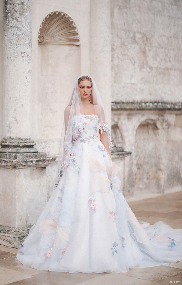 Woman wearing DP456 Rapunzel - Disney Fairytale Weddings Wedding Dress in front of a classic stone building.  