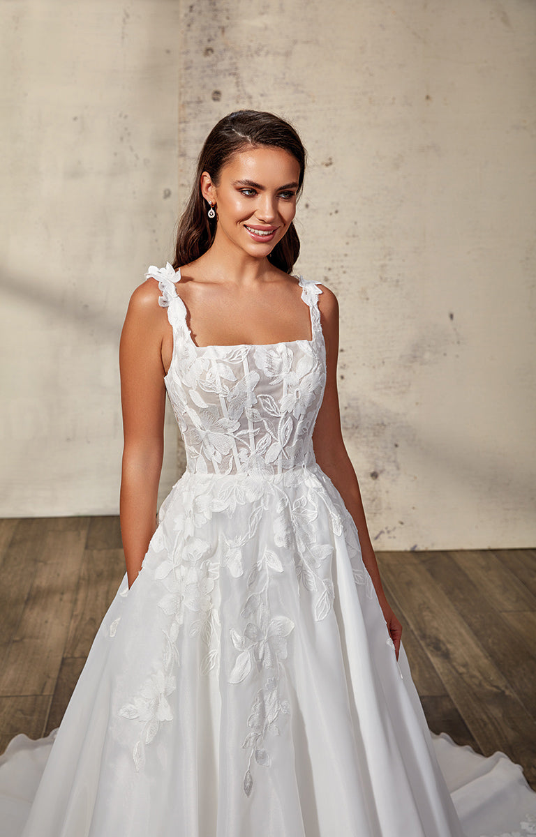 Woman wearing a white wedding dress against a neutral background