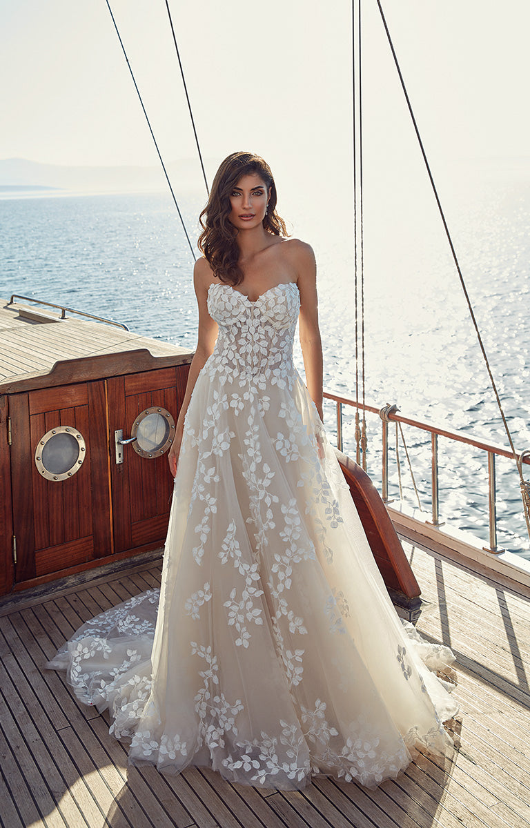 Woman in a strapless floral wedding dress on a boat with ocean view