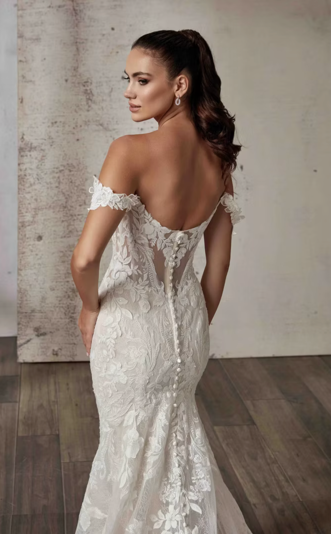 Woman wearing a white lace wedding dress with a neutral background