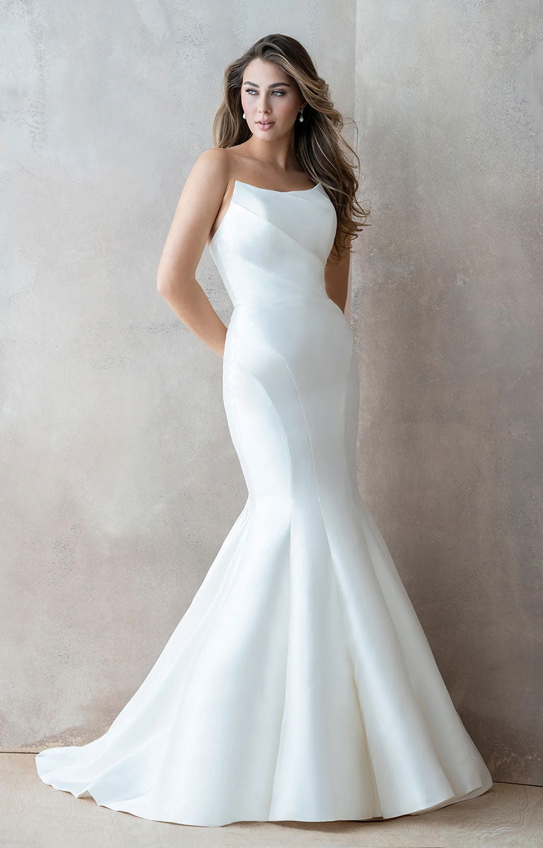 Woman wearing Carmen E215 by Abella Bridal - Strapless Minimalist Wedding Dress with Dramatic Neckline against a neutral background