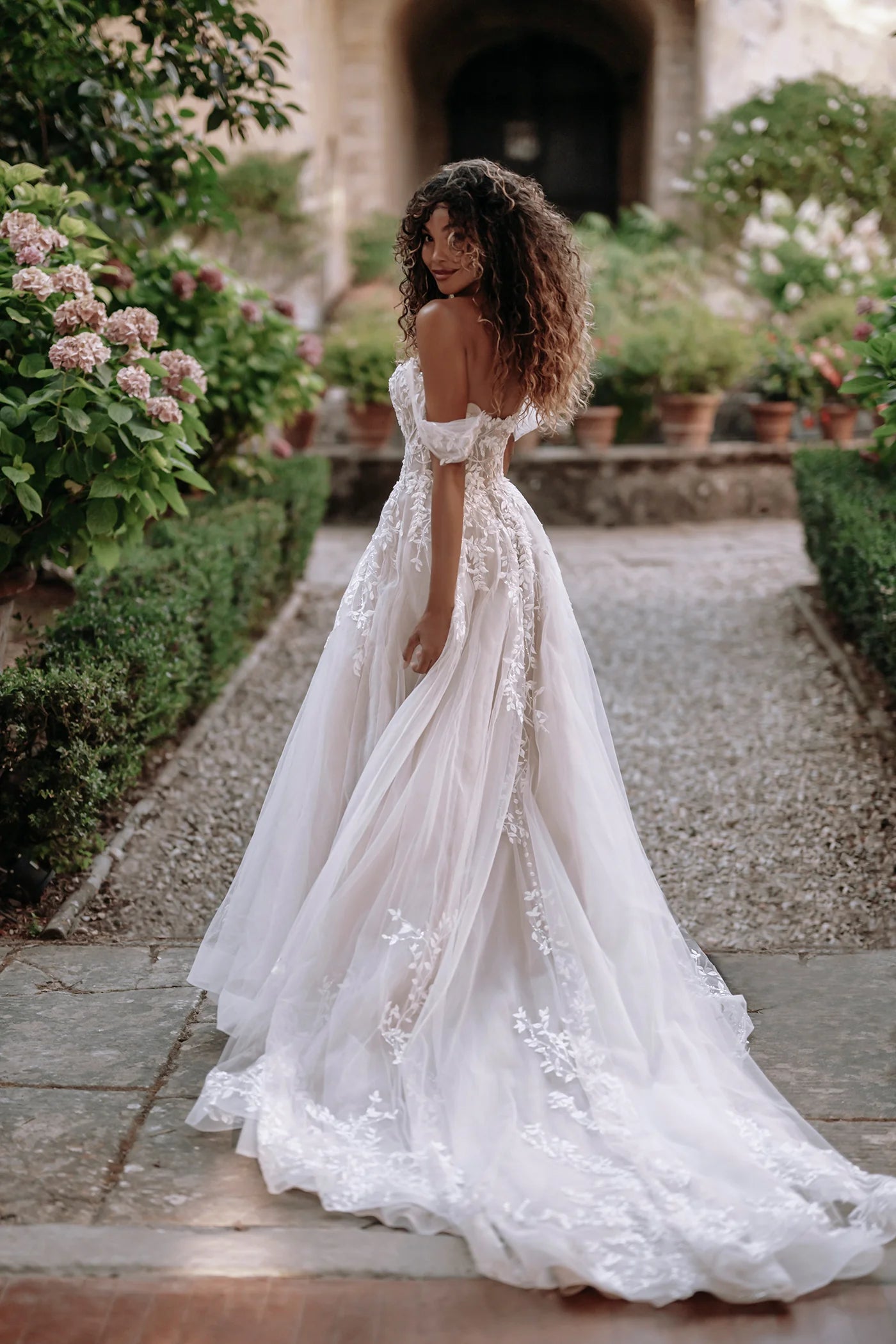 Woman in a white wedding dress standing in a garden setting