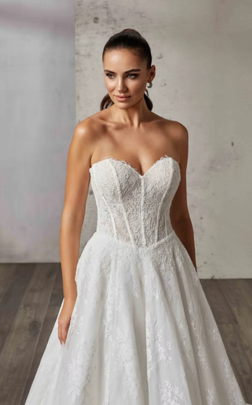 Woman wearing a strapless lace wedding dress against a neutral background