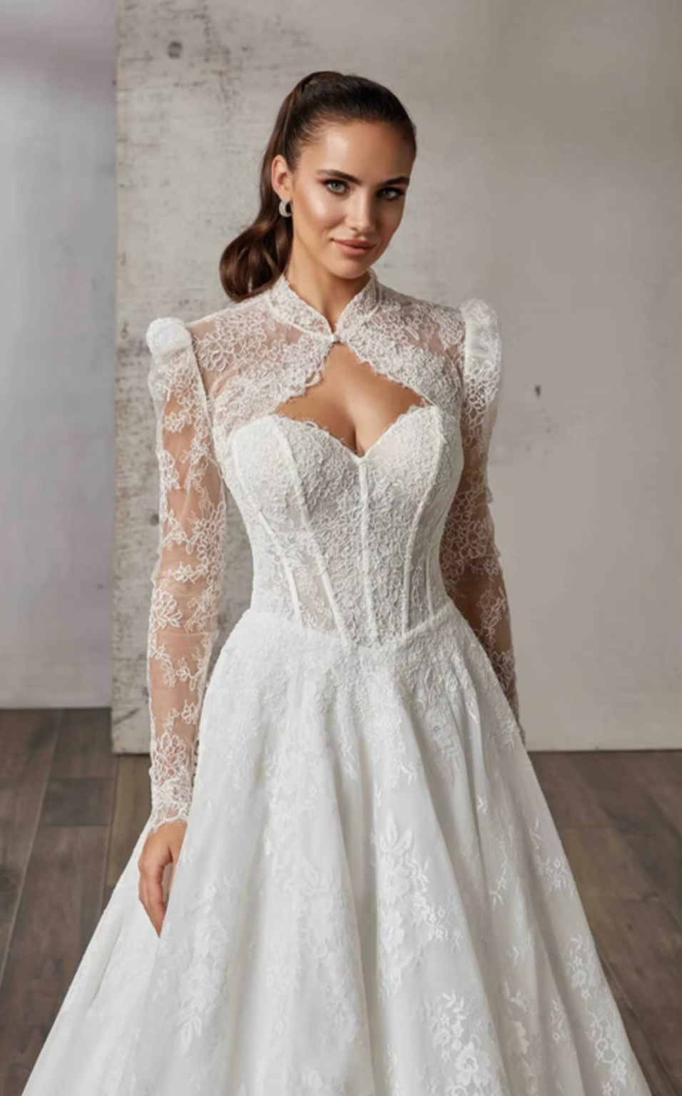 Woman wearing a white lace wedding dress with matching lace long sleeve jacket against a neutral background
