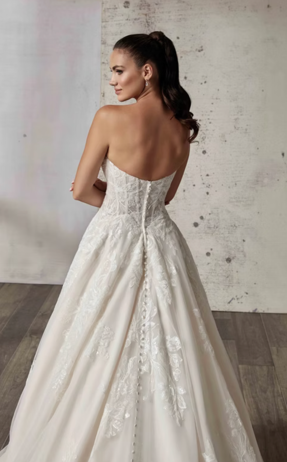 Woman wearing a white wedding dress with a textured wall background