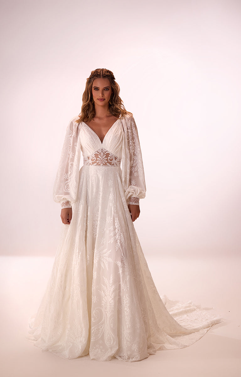 Woman wearing a white lace wedding dress with long sleeves on a white background