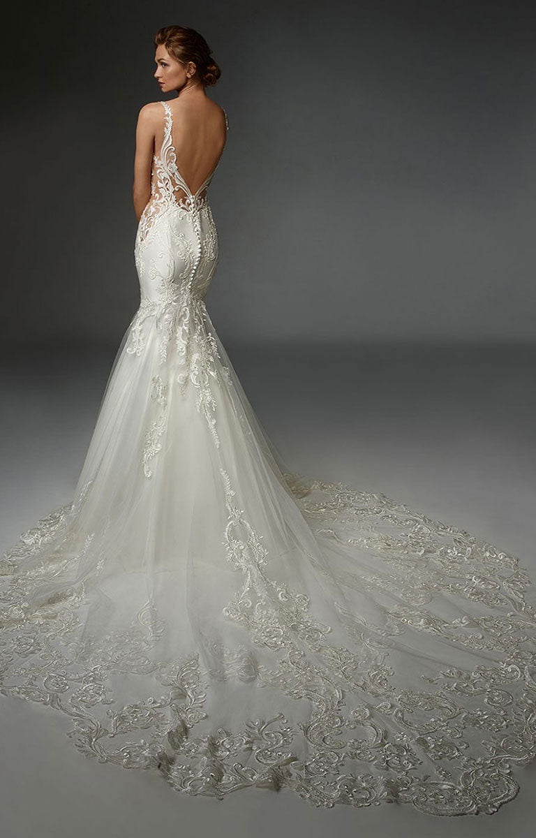 Elegant Henriette by ÉLYSÉE - Graphic Lace Wedding Dress with Illusion Bodice and Beaded Detailing with a long train on a dark background