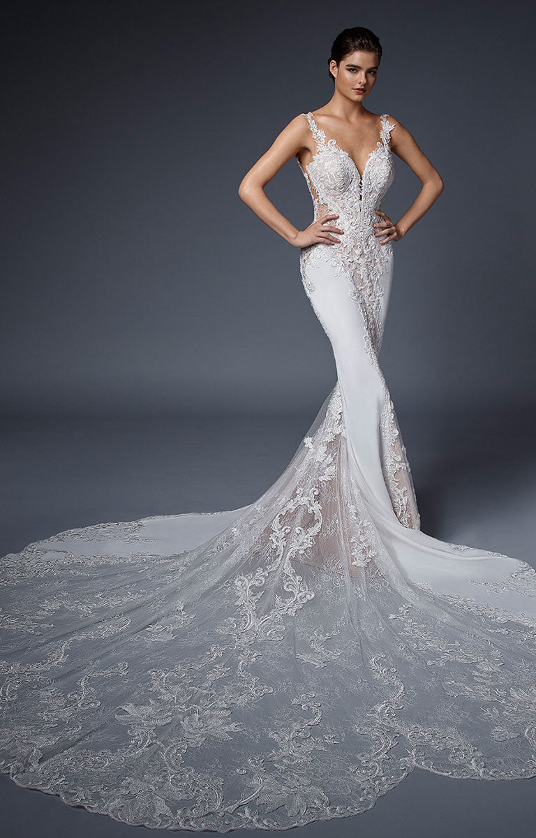 Nadiya by ÉLYSÉE - Illusion Lace Fit and Flare Wedding Dress with Beaded Train on a model against a dark background