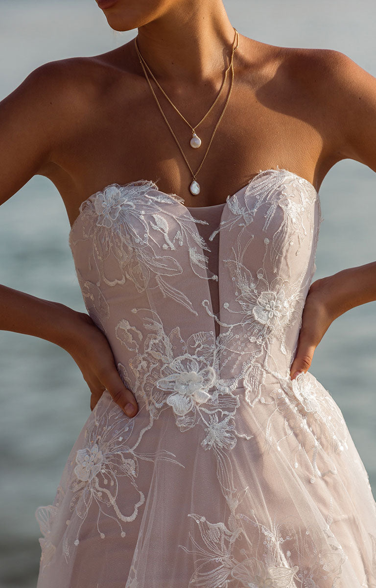 Close-up of Janae by Madi Lane - A-Line Wedding Dress with Detachable Sleeves and Illusion Train with a blurred background