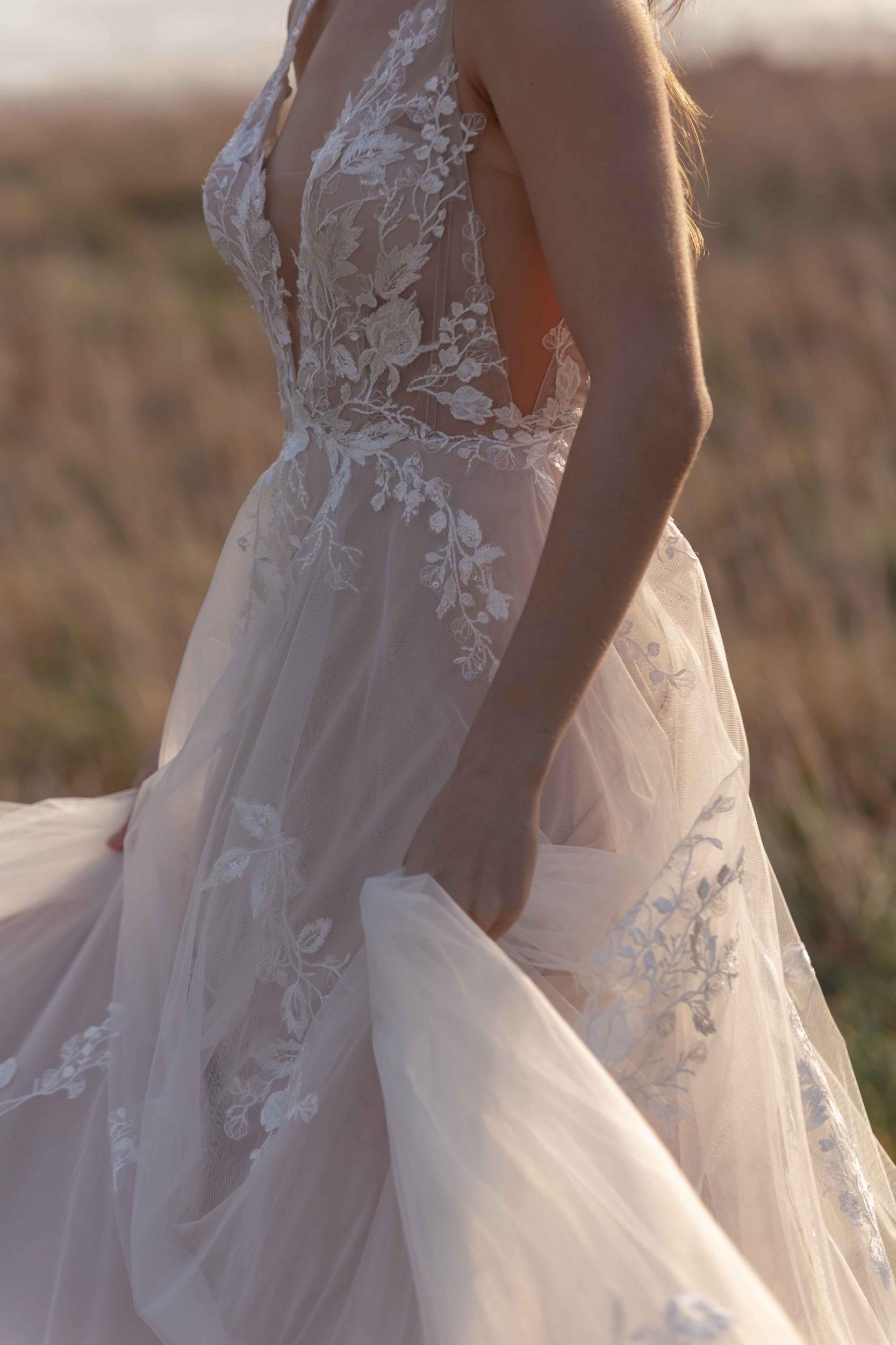 Lace wedding dress in a field with a blurred background