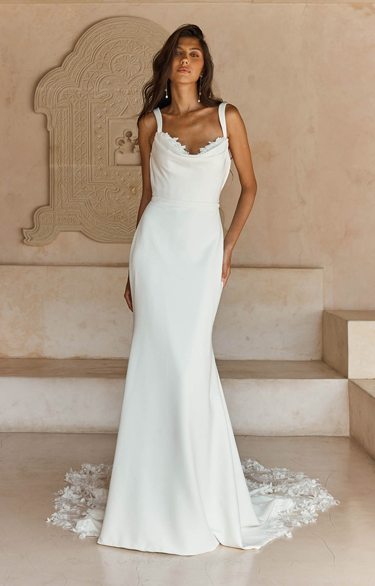 Woman wearing Lanette by Madi Lane,  a white wedding dress with floral details in an elegant setting.