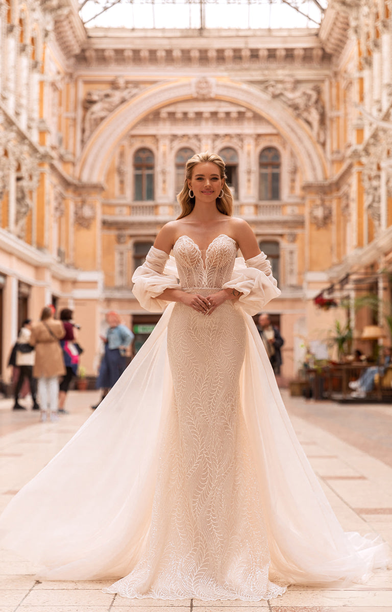 Woman in a white wedding dress standing in an elegant architectural setting