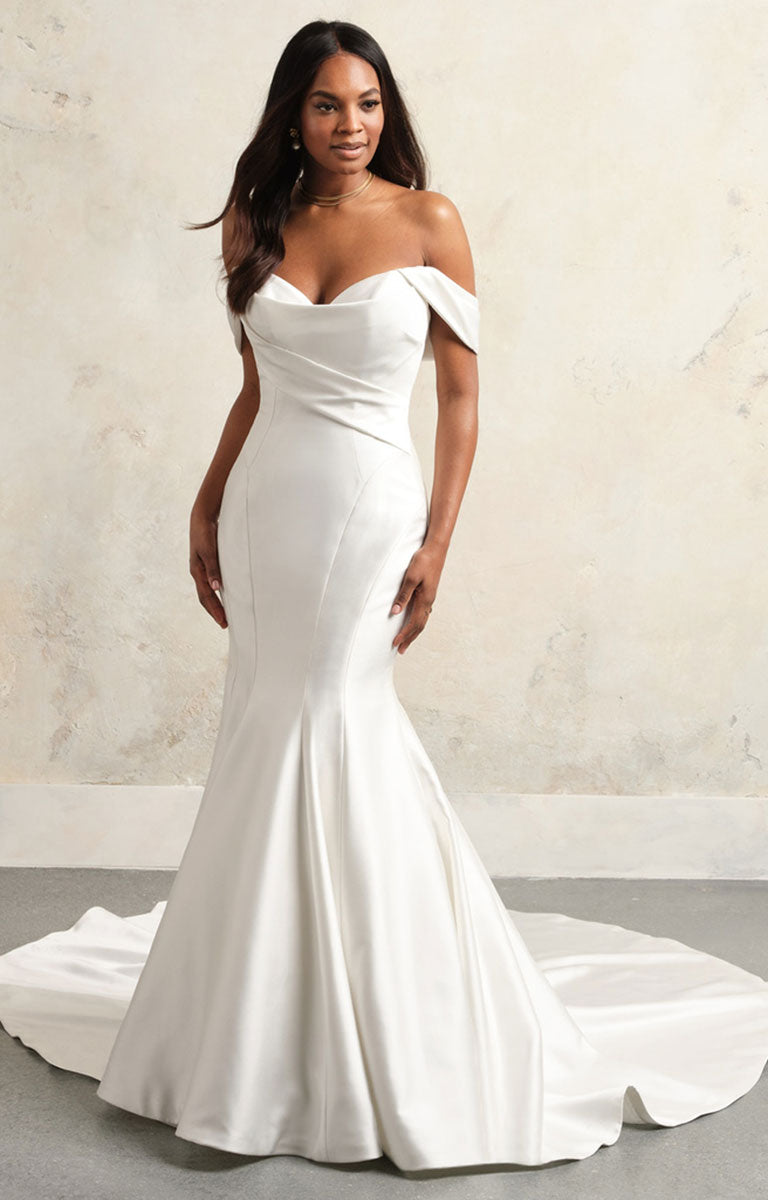 Woman wearing a white off-shoulder wedding dress against a neutral background