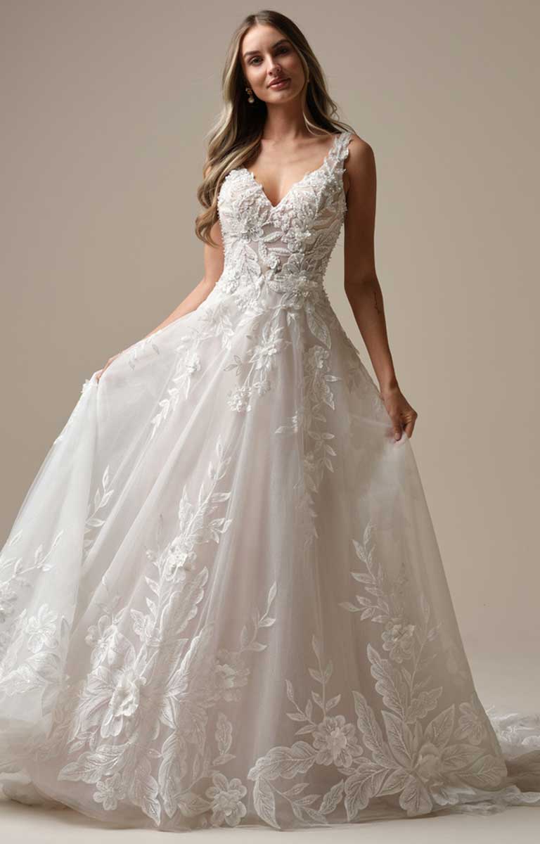 Woman wearing a white lace wedding dress against a neutral background