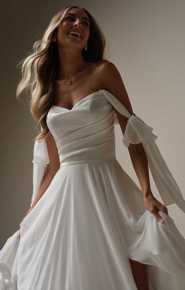 Woman wearing a white wedding dress with a plain background